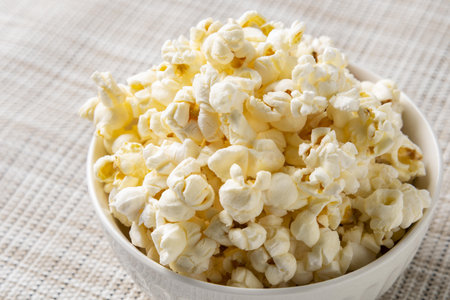 Popcorn in a bowl on a white background. Selective focus.の写真素材