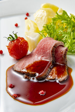 roast beef with mashed potatoes and vegetables on a white background in the restaurantの写真素材