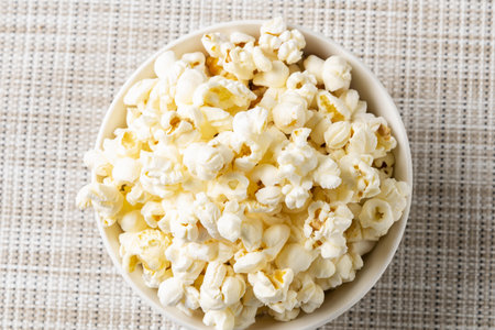 Popcorn in a bowl on a white background, top view.の写真素材