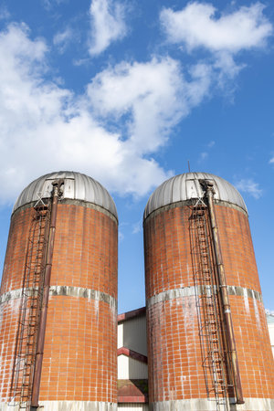 Grain silos with blue sky and white clouds in the backgroundの写真素材
