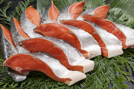 Raw salmon fillets on a black wooden table. Top view.の写真素材