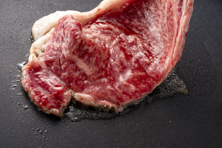 Raw fresh beef steak on black background, top view, copy spaceの写真素材