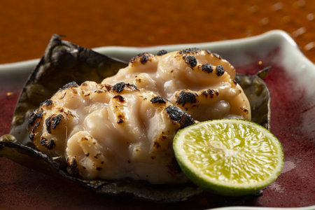 grilled scallops in oyster shell with sauce and limeの写真素材