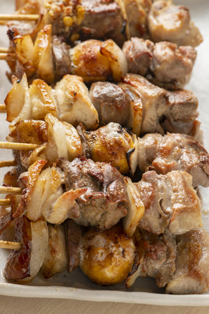 Skewers of pork and potatoes on a baking sheet.の写真素材