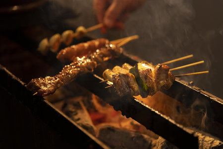 Grilled meat on skewers on the grill in the restaurant.の写真素材