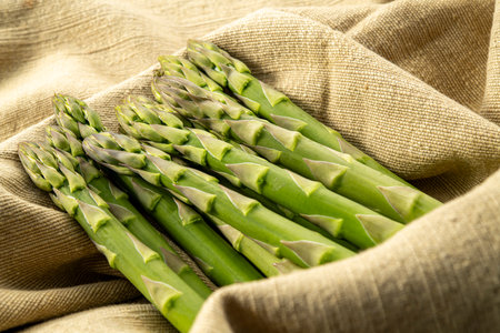 Bunch of fresh asparagus on sackcloth, closeupの写真素材