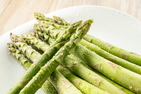 Asparagus on a white plate with water droplets on itの写真素材