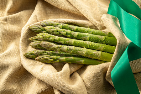 Bunch of fresh green asparagus on a sackcloth backgroundの写真素材