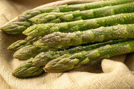 Bunch of fresh green asparagus spears on sackcloth backgroundの写真素材