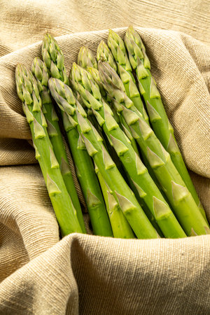 Bunch of fresh green asparagus spears on burlap backgroundの写真素材