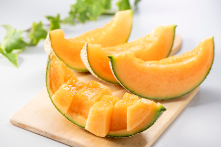 Melon slices on a wooden board on a white background, close-upの写真素材