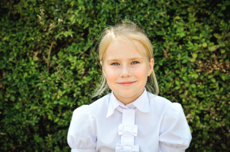 Outdoor portrait of adorable little girl in white blouse