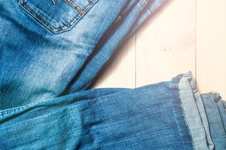 Blue jeans on a wooden background.Frayed jeans on a rough wood surface.の写真素材