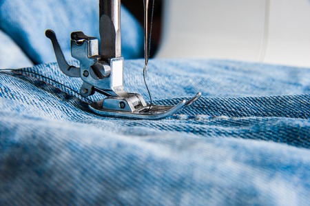 Sewing machine and blue jeans fabric close upの写真素材