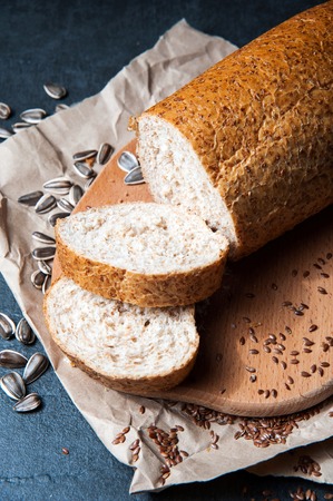Bread with bran and seeds. Sliced is on the board for cutting