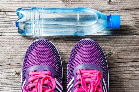 Violet sports runners and a bottle of waterの写真素材
