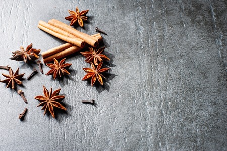 Cooking ingredients: cinnamon sticks, clove and star anise on dark stone tableの写真素材
