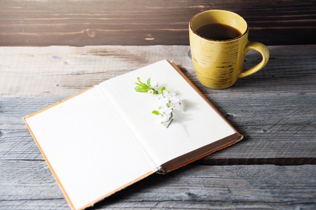 Photo blank book cover on textured wood background with spring flower and cape of coffeeの写真素材