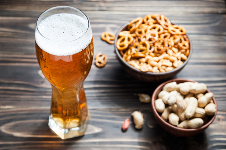 Beer with Pretzels, Crackers and Nuts on wooden tableの写真素材