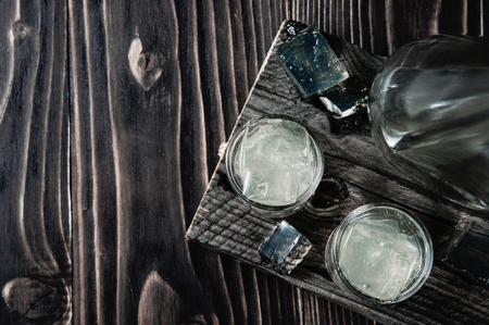 Vodka in shot glasses on rustic wood backgroundの写真素材