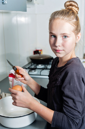 cute teen girl baker on kitchen with baking ingredientsの写真素材