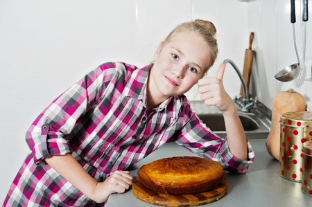 beautiful girl with cake in kitchenの写真素材