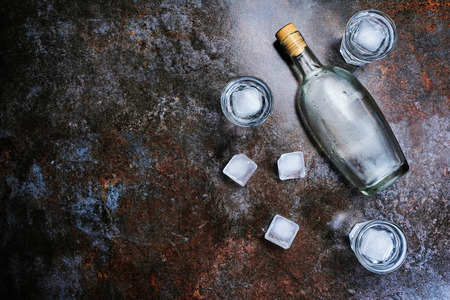Bottle of vodka with shot glasses. On stone background.の写真素材