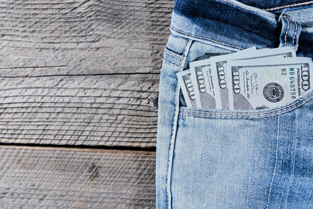 A one hundred dollar notes in the front pocket of denim trousers