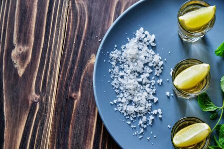 Tequila shot with lime and sea salt on grey plateの写真素材