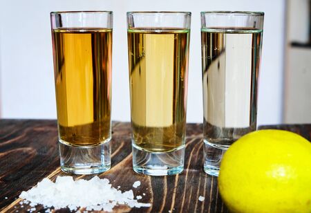 Mexican gold and silver tequila and lime salt on wood backgroundの写真素材