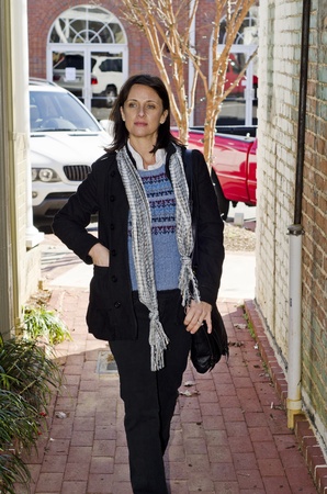 woman walking cautiously down an alley wayの写真素材