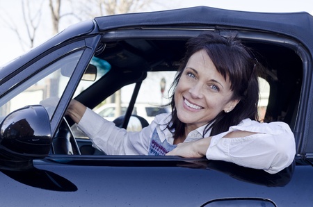 Pretty woman looking out her car window smilingの写真素材