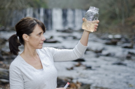 Female researcher checking the water quality from a riverの写真素材