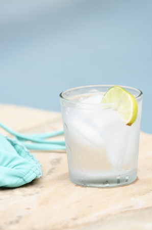 bikini top and a cold drink by the edge of the poolの写真素材