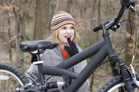 Young kid fixing something on his bikeの写真素材