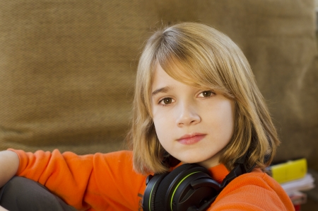 Young teen boy sitting with head phones on his neckの写真素材