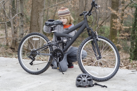 Young boy dismounts bike to make a repairの写真素材