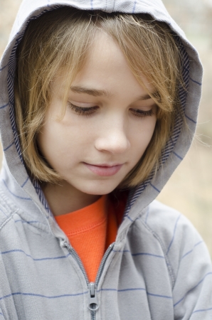You preteen boy wearing a hoodie and feeling downの写真素材
