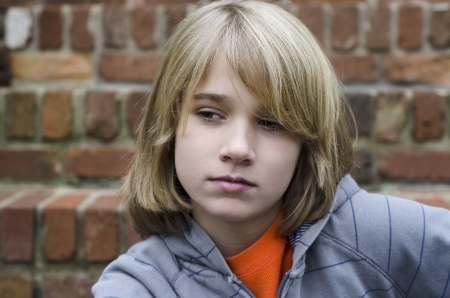 young kid sitting on stairs thinking something overの写真素材