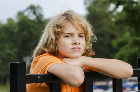 Young teen is sitting around bored in the Summerの写真素材