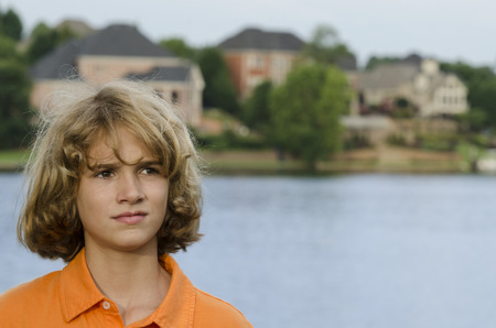 Boy from a wealthy family poses by the lake in their communityの写真素材