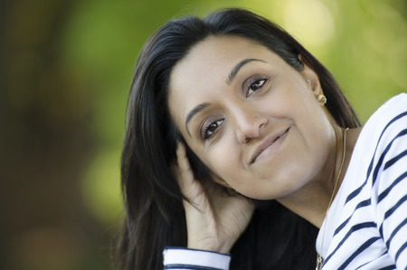 Beautifully elegant young Indian woman watching youの写真素材