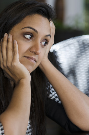 upset young Indian woman thinks about her problemsの写真素材