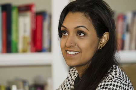 Pretty young Indian woman in conversation with someoneの写真素材