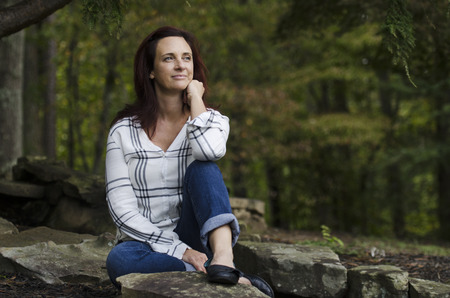 Woman sitting outside on some rocksの写真素材