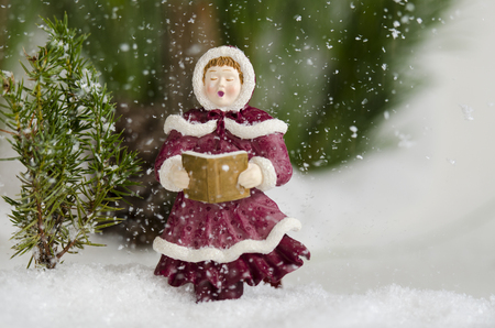 Caroler sing in the snow fall