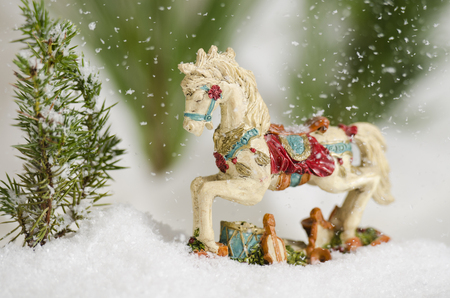 Antique Christmas ornamental horse in the falling snowの写真素材