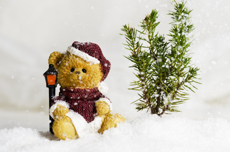 Christmas bear ornament in the falling snowの写真素材