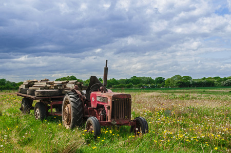 Abandoned Old Red Farm Tractor in Meadowの写真素材