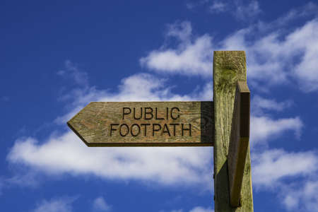 Wooden public footpath sign against blue sky backgroundの写真素材